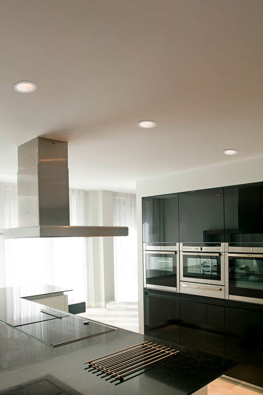 Luminaria empotrable FOX 40 blanco 5W LED 2700K 25° faro instalada en techo interior comercial hospitality, aluminio regulable emitiendo luz cálida ambiente