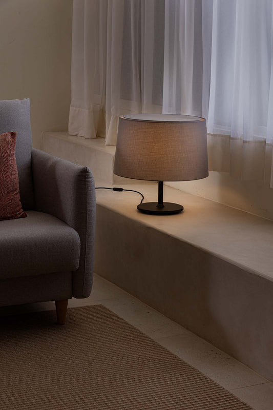 Lámpara de sobremesa Windsor negra y gris de FARO en ambiente interior de restaurante o hotel, diseño textil y acero para iluminación ambiente elegante, modelo 20225-130.