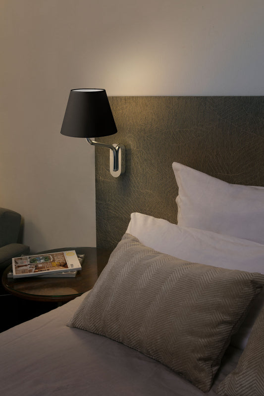 Imagen de ambiente de aplique de pared Eterna en acabado cromo y negro de Faro (modelo 24005-12), luminaria superficie para interiores en acero y textil, ideal para hoteles, restaurantes y negocios.