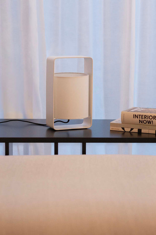 Lámpara sobremesa Lula S blanca de Faro, diseño Marinas Milá en acero y textil, iluminando ambiente interior de salón moderno.