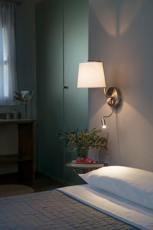 Aplique de pared BERNI en níquel satinado de FARO (29331) en ambiente interior minimalista, luminaria de superficie en acero y textil con lector LED integrado.