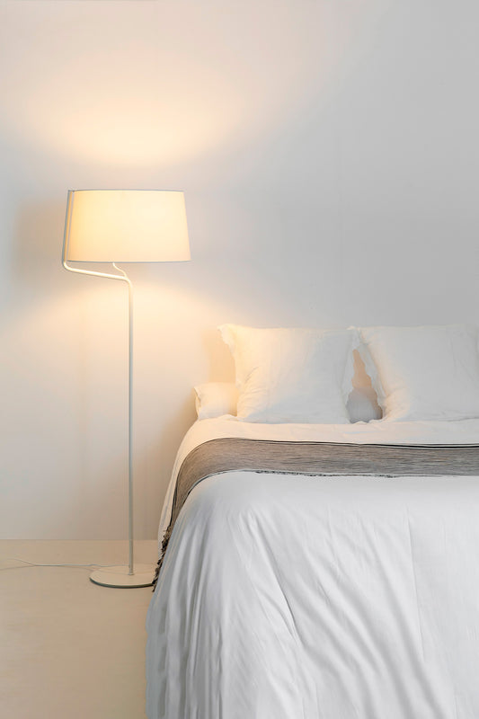 Lámpara de pie BERNI en blanco de FARO (modelo 29335) en ambiente de salón moderno, iluminando espacio interior con diseño elegante de acero y pantalla textil.