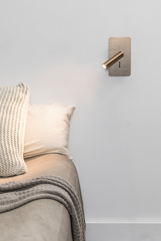 Lámpara de pared SUAU Aplique Lector en bronce FARO 62104, en ambiente interior minimalista iluminando zona de lectura con luz LED cálida, diseño Nahtrang.