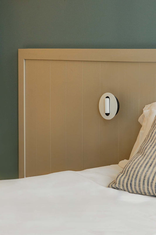 Aplique de pared TIMIT Lector en blanco de FARO modelo 62762, luminaria de superficie interior con LED integrado, diseño minimalista en acero y aluminio, montado en ambiente hogareño iluminando pared blanca, wall light moderna para interiores.