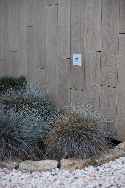 Imagen ambiente de empotrable LED exterior DART SQ blanco 3000K FARO 70272N instalado en pared outdoor, luminaria empotrada de policarbonato y cristal para iluminación y señalización cálida 3000K.