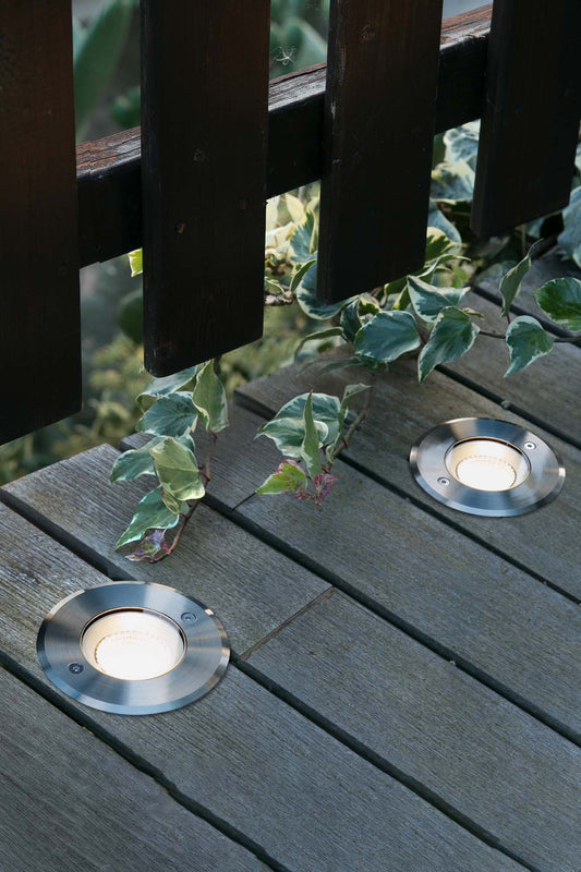 Imagen ambiente de luminaria empotrable LED SURIA 120 Inox 60° modelo FARO 70592N instalada en jardín exterior iluminando terrazas con resistencia IP67 e IK08