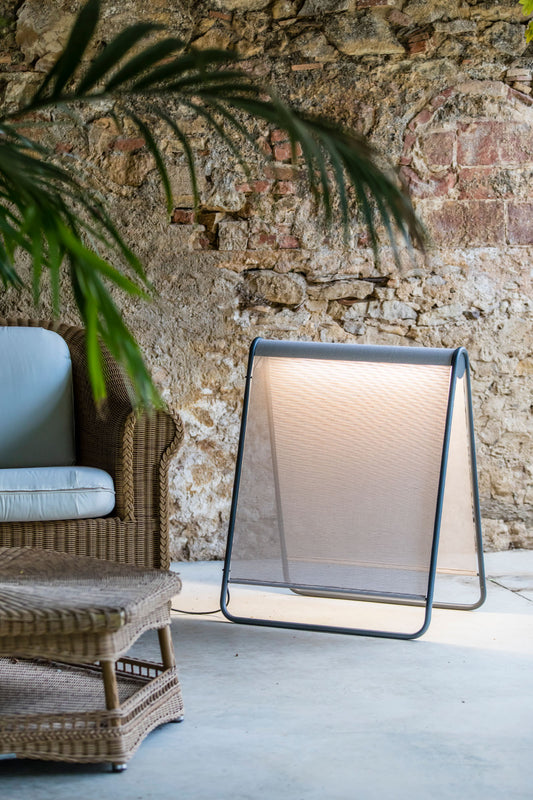 Lámpara de pie exterior Cadaqués en beige, modelo FARO 71242, iluminando jardín o terraza con luz LED resistente al agua, luminaria de superficie ideal para exteriores