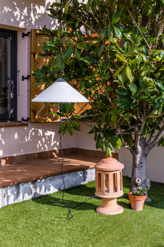 Lámpara portátil SAIGON OUT R55 gris oscuro y blanco mate de FARO (71584-01) en ambiente de jardín minimalista, iluminación colgante exterior en aluminio para terraza.