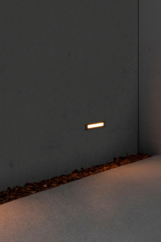 Faro empotrable LED FALLS 290 6W 2700K acero inoxidable IP67 en ambiente de jardín o terraza, luminaria exterior para iluminación cálida en paisajes.