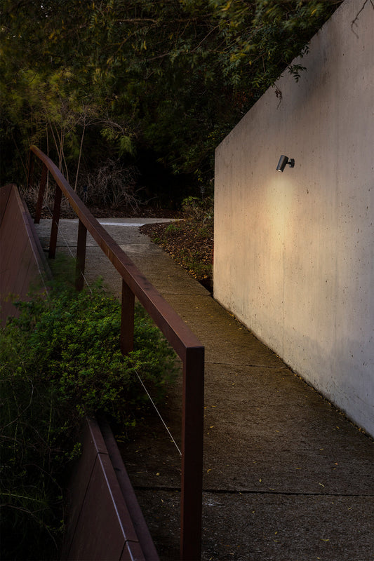 Proyector exterior PUK 59 negro 15° 2700K FARO 75302-221 en imagen ambiente de jardín, luminaria LED IP65 para iluminación acento arquitectónica