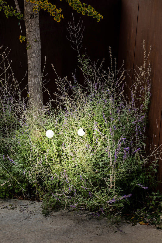 Baliza exterior CUCA 650 negra de acero inoxidable con cristal opal y LED, faro minimalista IP65 para jardín, modelo 75567 en entorno luminoso moderno