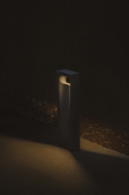 Baliza exterior GLINT 700 gris 2700K faro LED IP55 instalada en jardín de cemento para patio y luminaria superficie modelo 75638