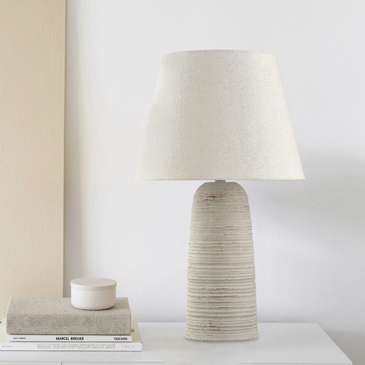 Rinconera Noola Beige colocada en rincón de sala decorada