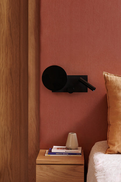 Imagen ambiente de aplique de pared KLEE Derecho Negro con lector LED COB de FARO (modelo 20058), luminaria de superficie en negro texturizado para iluminación de lectura en hogar moderno interior.