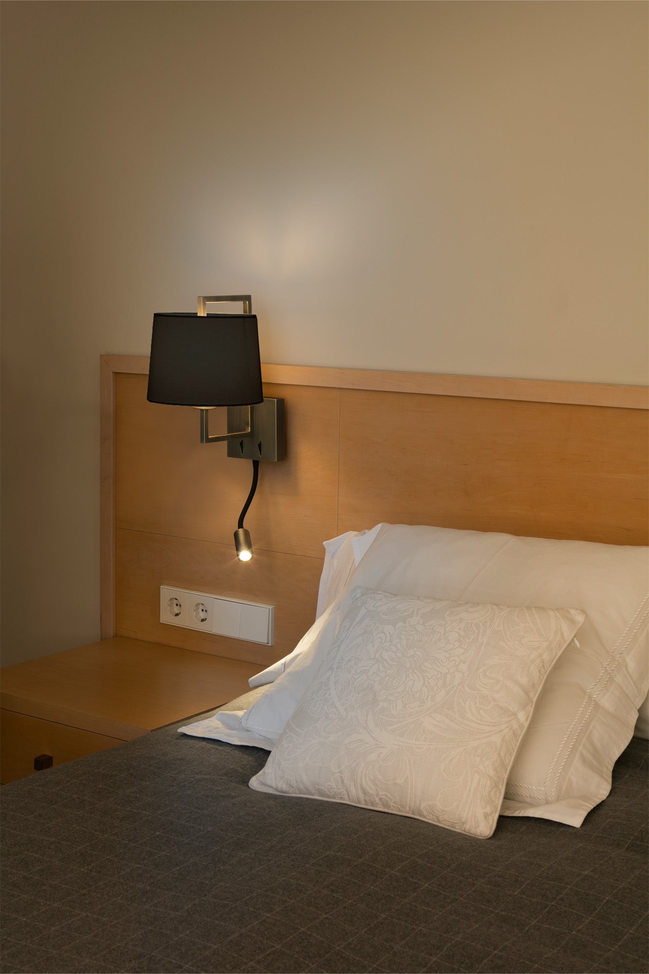 Ambiente de luminaria de pared FRAME oro viejo mate/negra LED FARO 20173-03 en dormitorio interior, ideal para hoteles y restauración