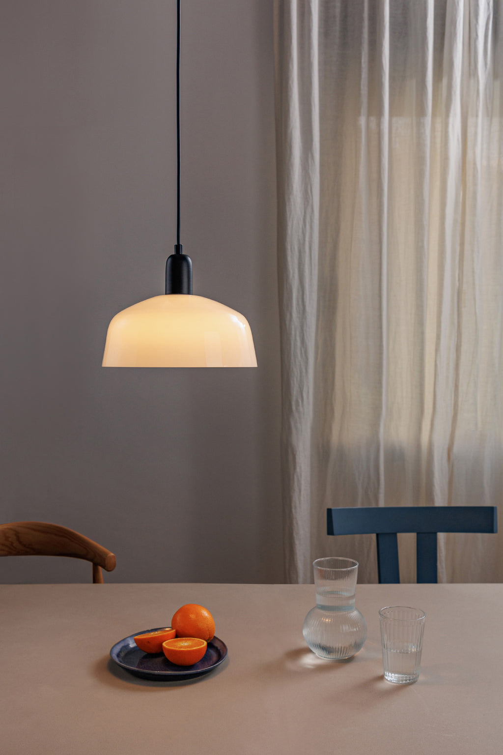 Luminaria colgante Tatawin M en cristal blanco de FARO 20339-119, suspendida en ambiente interior moderno con diseño de acero negro satinado y suspensión elegante.