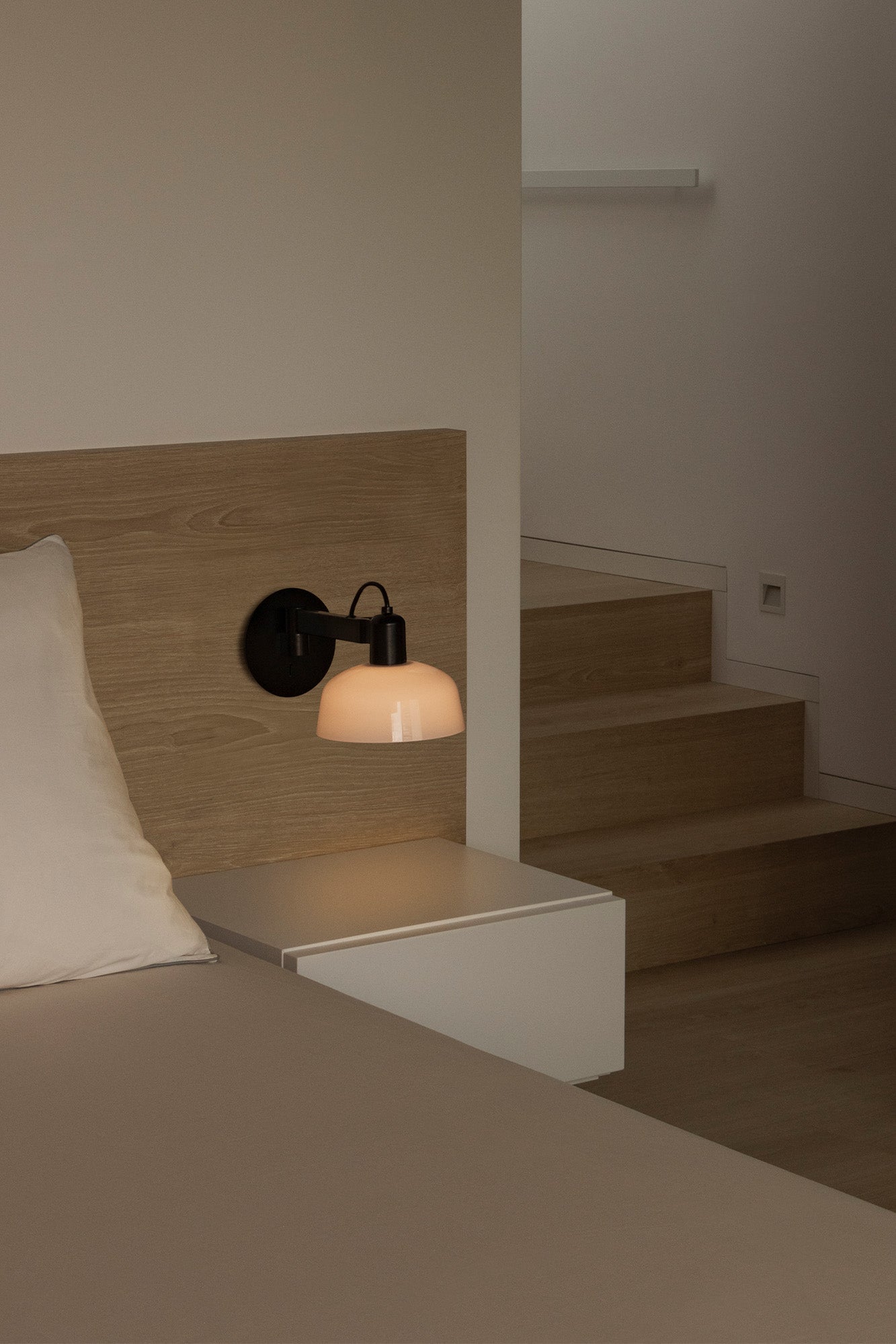 Aplique de pared TATAWIN Cristal Blanco FARO 20342-116 en ambiente moderno de interior, luminaria superficie orientable con cristal opal y acero negro satinado, diseño Adolfo Abejón colección 2047