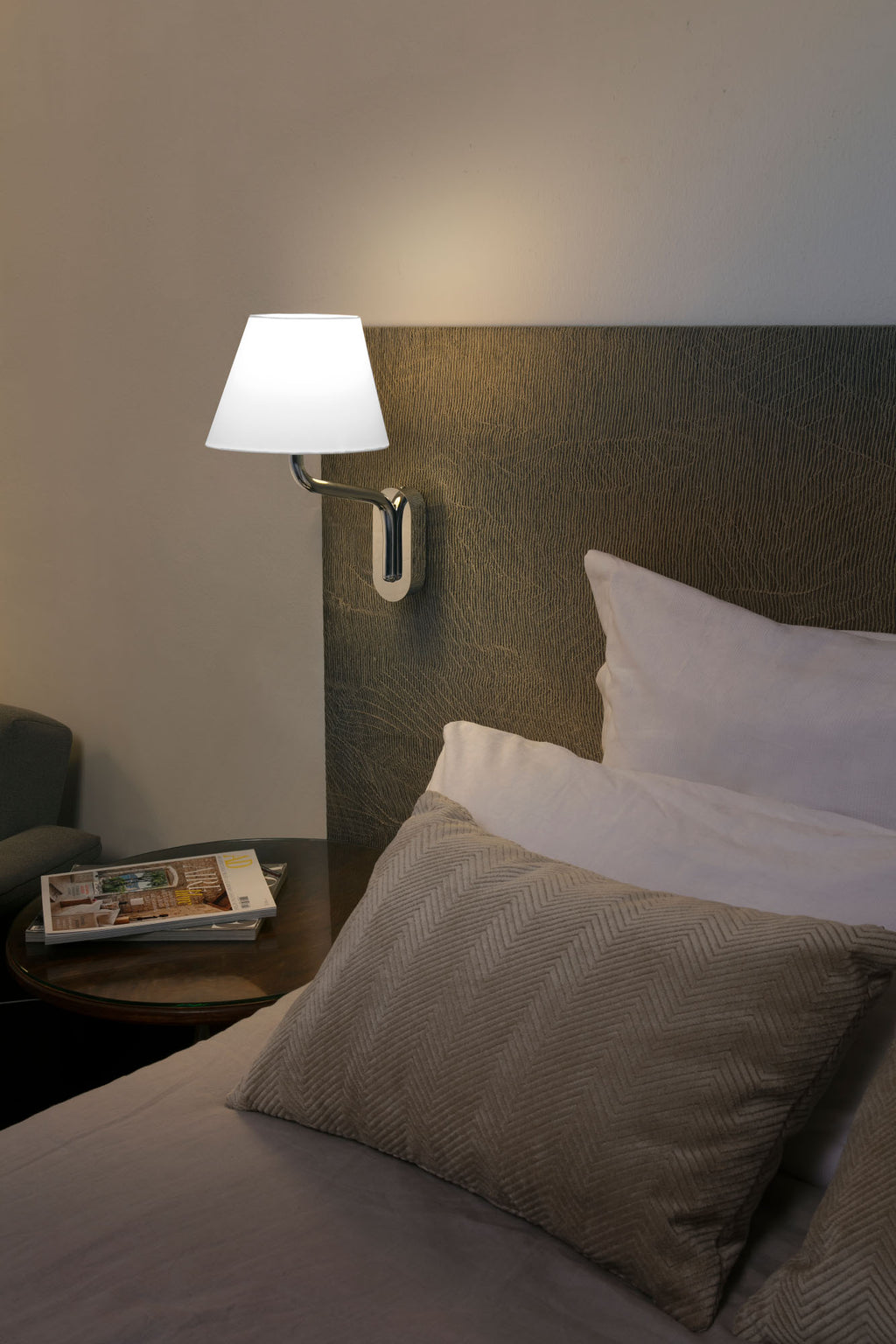 Aplique de pared Eterna cromo/blanco de Faro (modelo 24005-10) en ambiente interior hotelero, luminaria superficie textil con diseño lucido y cromado elegante para iluminación hotel.