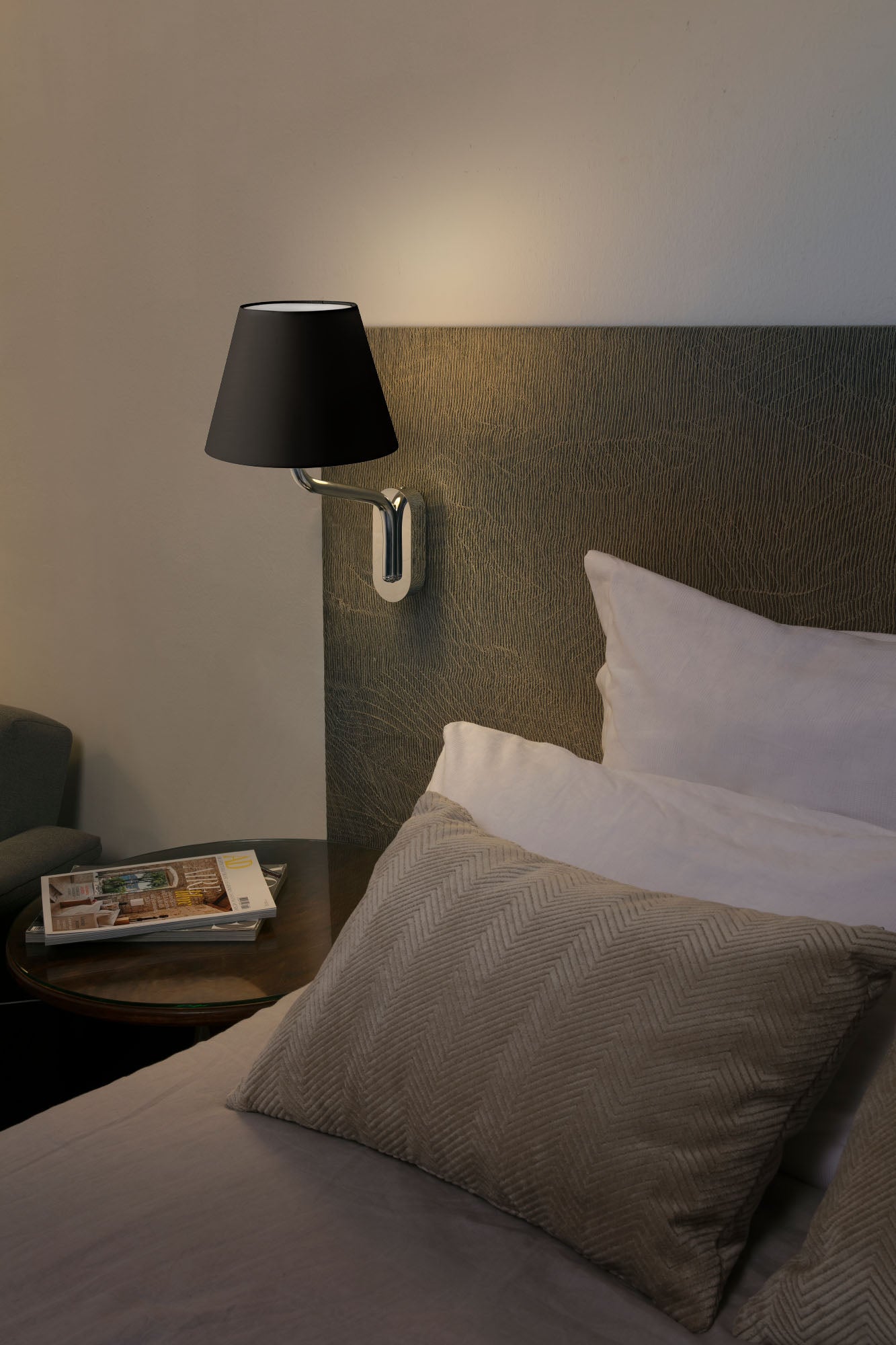 Imagen de ambiente de aplique de pared Eterna en acabado cromo y negro de Faro (modelo 24005-12), luminaria superficie para interiores en acero y textil, ideal para hoteles, restaurantes y negocios.