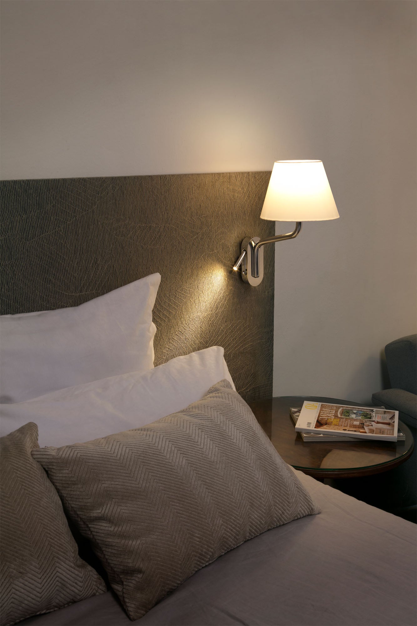 Imagen ambiente de aplique de pared Eterna de Faro modelo 24006-11 en cromo y beige con lector integrado derecho, luminaria superficie para interior hotelero en acero cromado y textil beige.