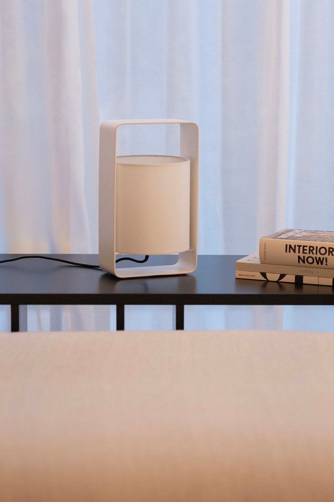 Lámpara sobremesa Lula S blanca de Faro, diseño Marinas Milá en acero y textil, iluminando ambiente interior de salón moderno.