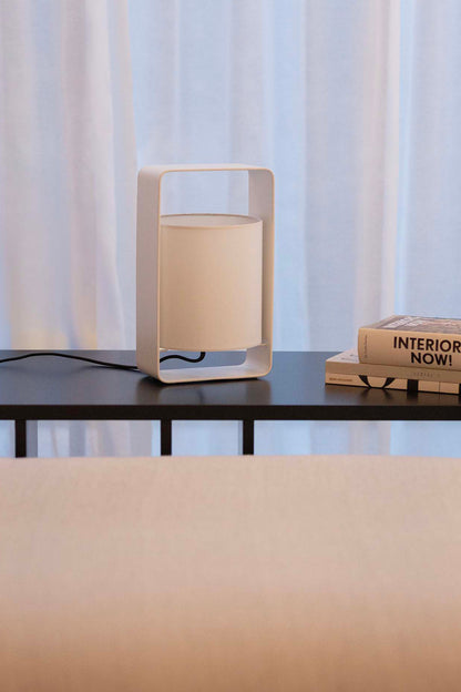 Lámpara sobremesa Lula S blanca de Faro, diseño Marinas Milá en acero y textil, iluminando ambiente interior de salón moderno.