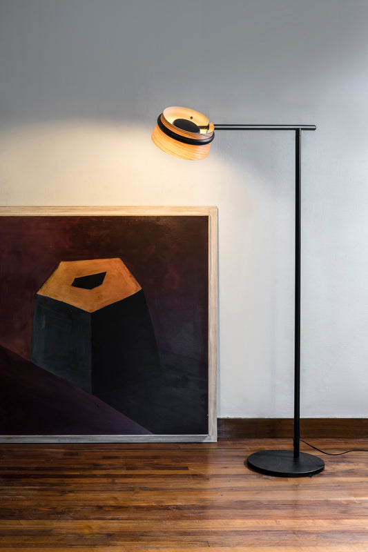 Lámpara de pie LOOP negro de FARO en ambiente interior moderno, diseño contemporáneo con madera de cerezo y acero negro, iluminación LED regulable ambiente.