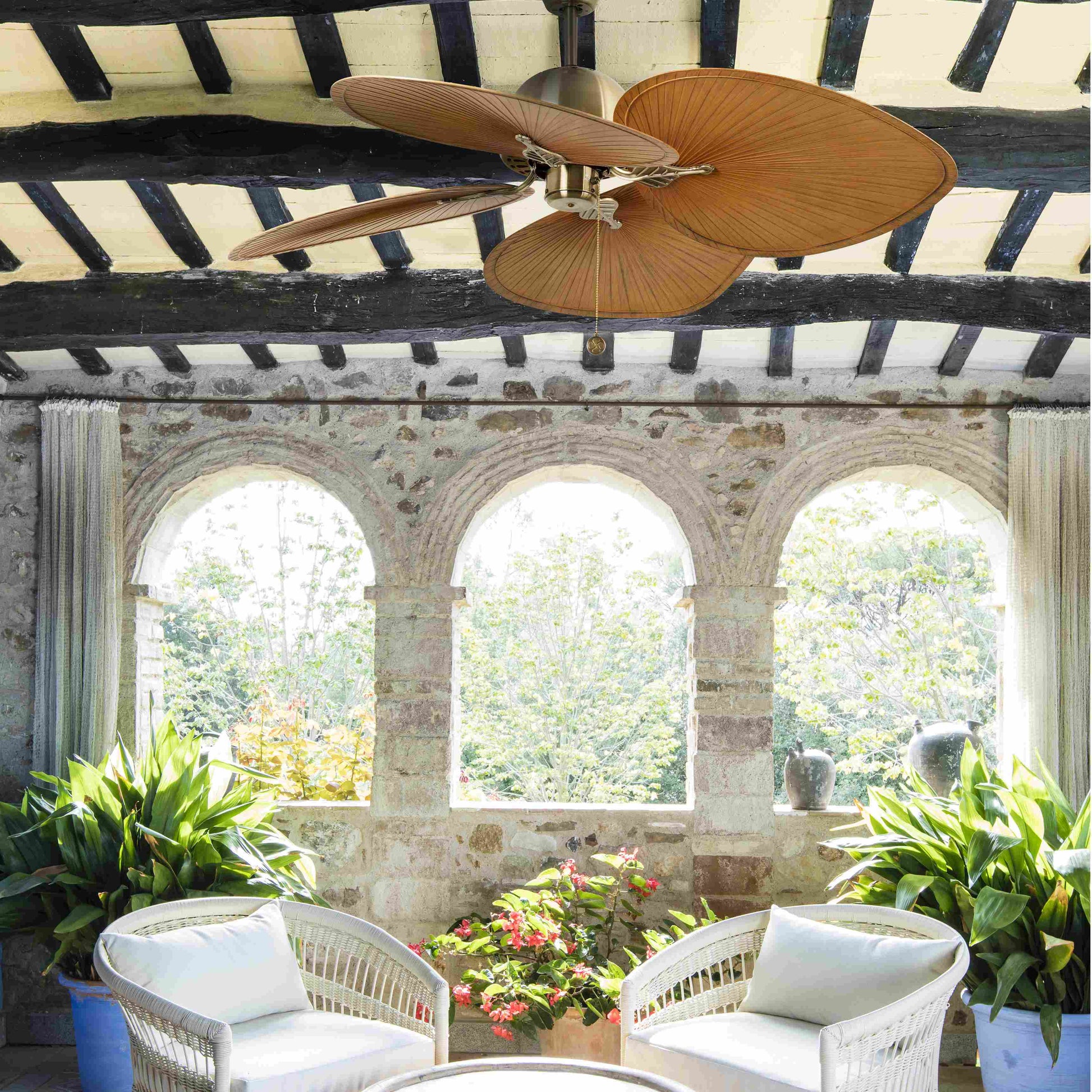 Ventilador de techo CUBA L en oro viejo y marrón de FARO, modelo 33352B de la colección 1009, en ambiente acogedor de sala con techos inclinados, diseño sin luz en acero y ABS para ventilación eficiente.