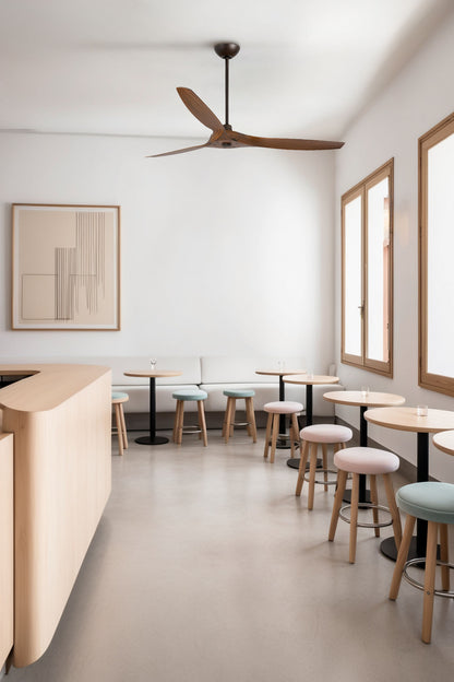 Ventilador de techo Morea L en marrón y nogal oscuro WIZ de Faro (modelo 33511WW) instalado en habitación luminosa de hogar con techos inclinados, ventilador sin luz con motor DC y mando a distancia para ventilación eficiente.