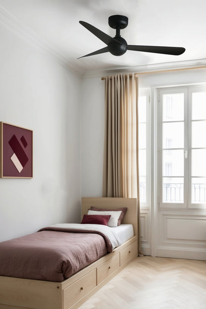 Ventilador de techo SFERA S negro modelo 34271 de FARO en ambiente acogedor de habitación pequeña, con motor DC eficiente, mando a distancia y diseño adaptable a techos inclinados para ventilación óptima sin luz integrada.