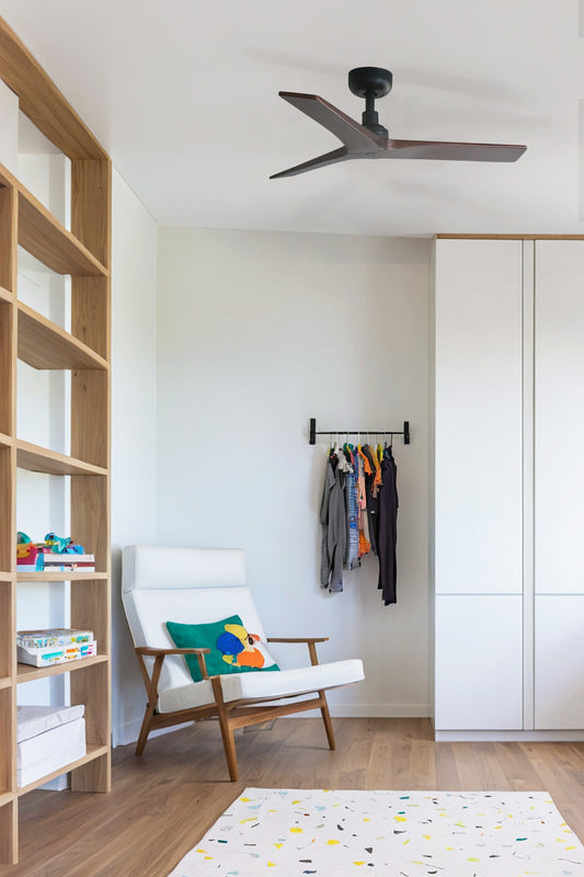 Ventilador de techo KLIM S negro y nogal oscuro de FARO (modelo 34278WW) instalado en ambiente hogareño con techos inclinados, diseño en madera y acero sin luz, con mando a distancia para ventilación en verano.