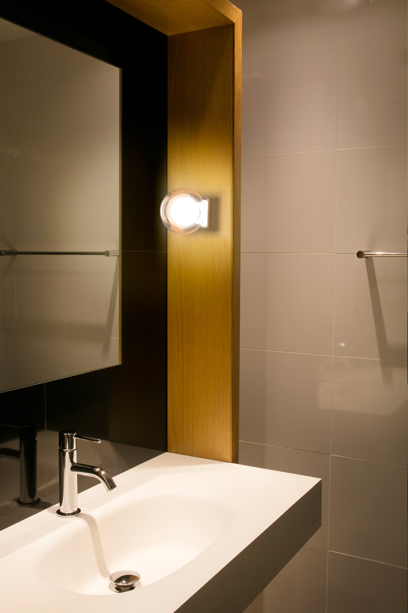 Imagen ambiente de applique de pared PERLA en cromo de FARO modelo 40086, luminaria de superficie en acero y cristal para baño interior, iluminando espejo.