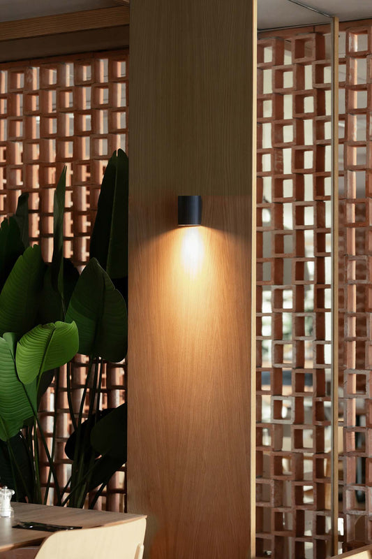 Imagen ambiente de aplique de pared SOLE redondo negro FARO modelo 40523, luminaria de superficie en aluminio y acero para pared interior, iluminación hogar moderna.