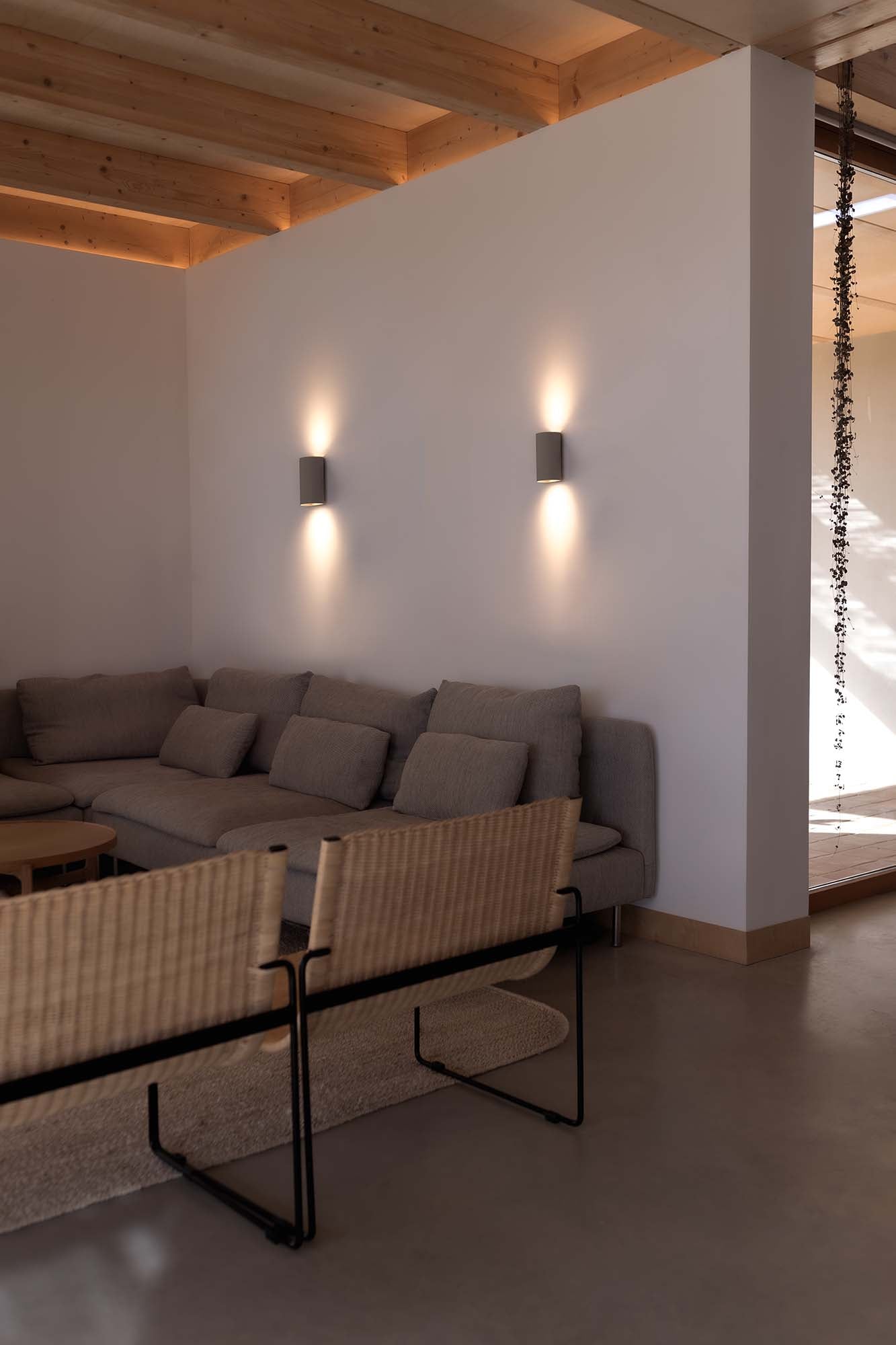 Imagen de ambiente del aplique de pared SOLE 2L Gris Redondo de FARO modelo 40540, luminaria superficie moderna en aluminio y acero, iluminando interior hogareño con luz indirecta en pared gris.