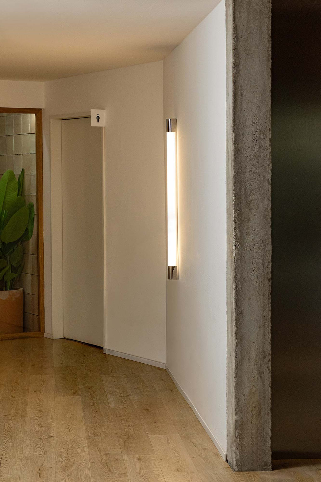 Aplique de pared KIVA 1200 cromado FARO modelo 62836 en ambiente interior, luminaria LED de acero inoxidable de 1200 mm para iluminación de superficie moderna.