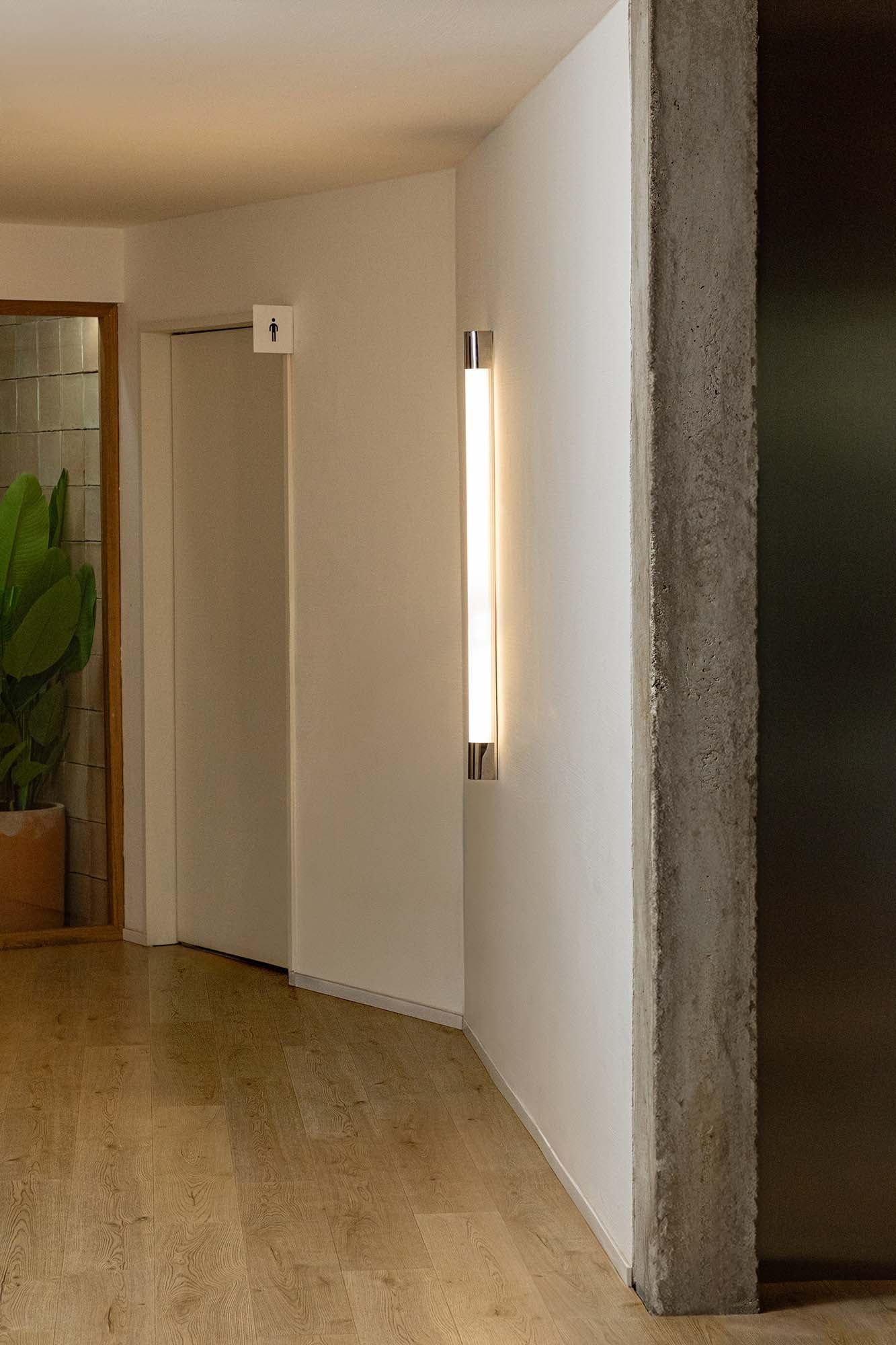 Aplique de pared KIVA 1200 cromado FARO modelo 62836 en ambiente interior, luminaria LED de acero inoxidable de 1200 mm para iluminación de superficie moderna.