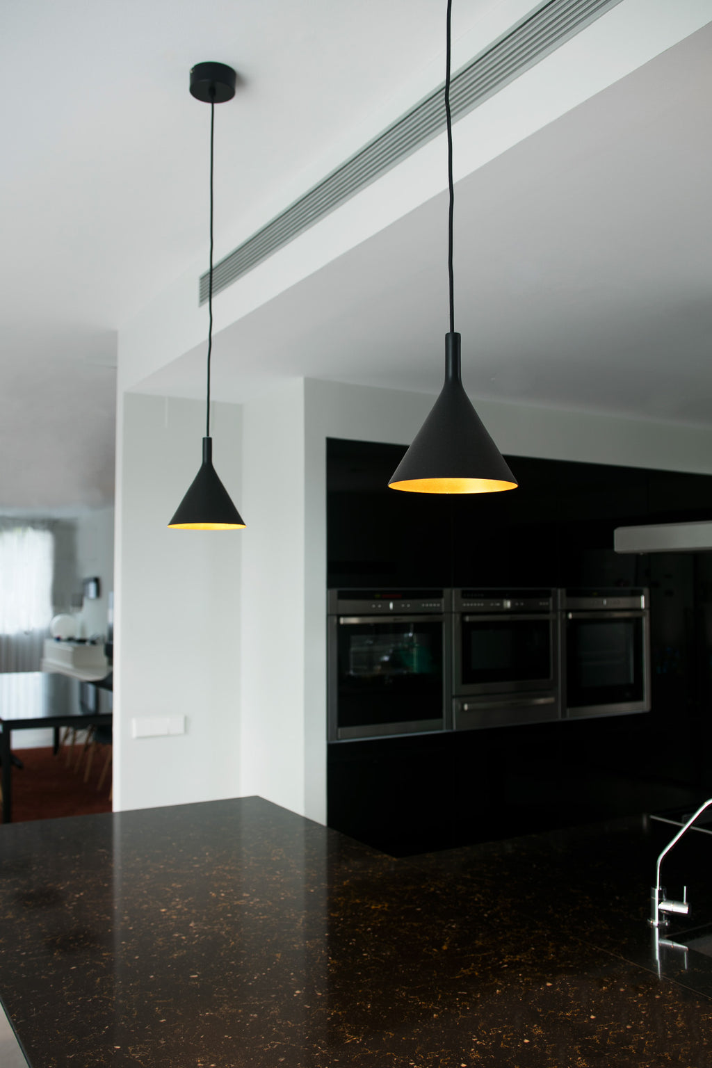 Lámpara colgante PAM 165 negra y oro de FARO (64160), diseño contemporáneo en acero y PMMA con iluminación LED, en ambiente de salón interior moderno.