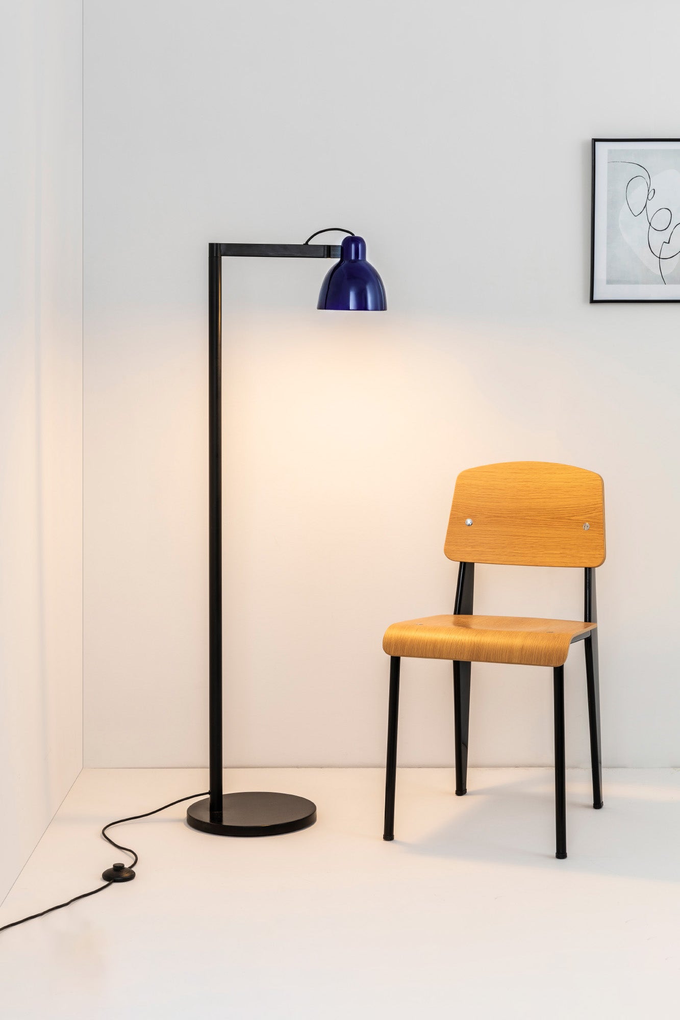 Lámpara de pie VENICE en azul cobalto de FARO (modelo 64275-115), diseño atemporal en cerámica y acero, iluminando un salón interior moderno con luminaria de superficie.