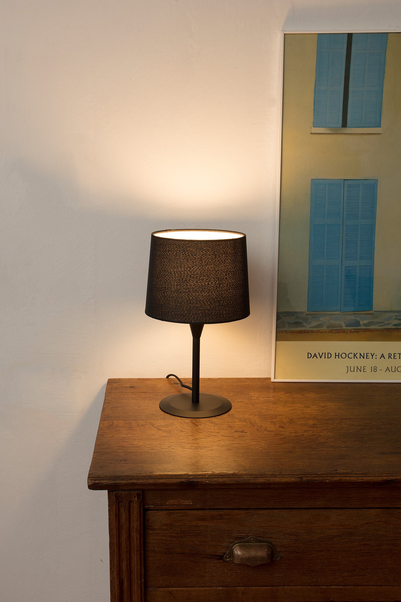 Lámpara de sobremesa CONGA S negra de FARO (64317-03) en ambiente interior de hogar, con estructura de acero y pantalla textil, ideal para iluminación acogedora en hospitality y decoración moderna.