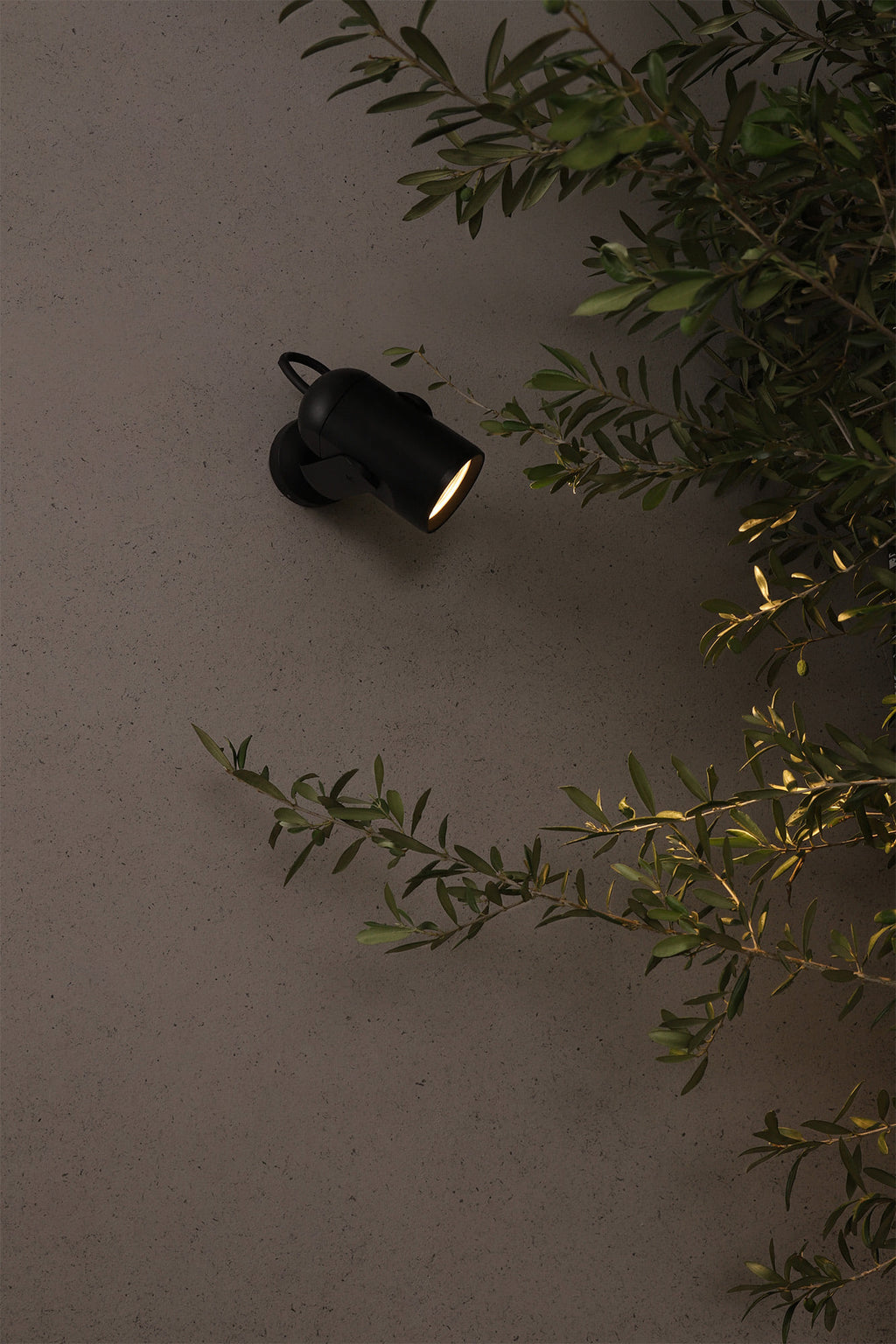 Proyector LED exterior SLOT 200 negro FARO IP65 de aluminio instalado en jardín, iluminando terraza y pared para iluminación exterior resistente