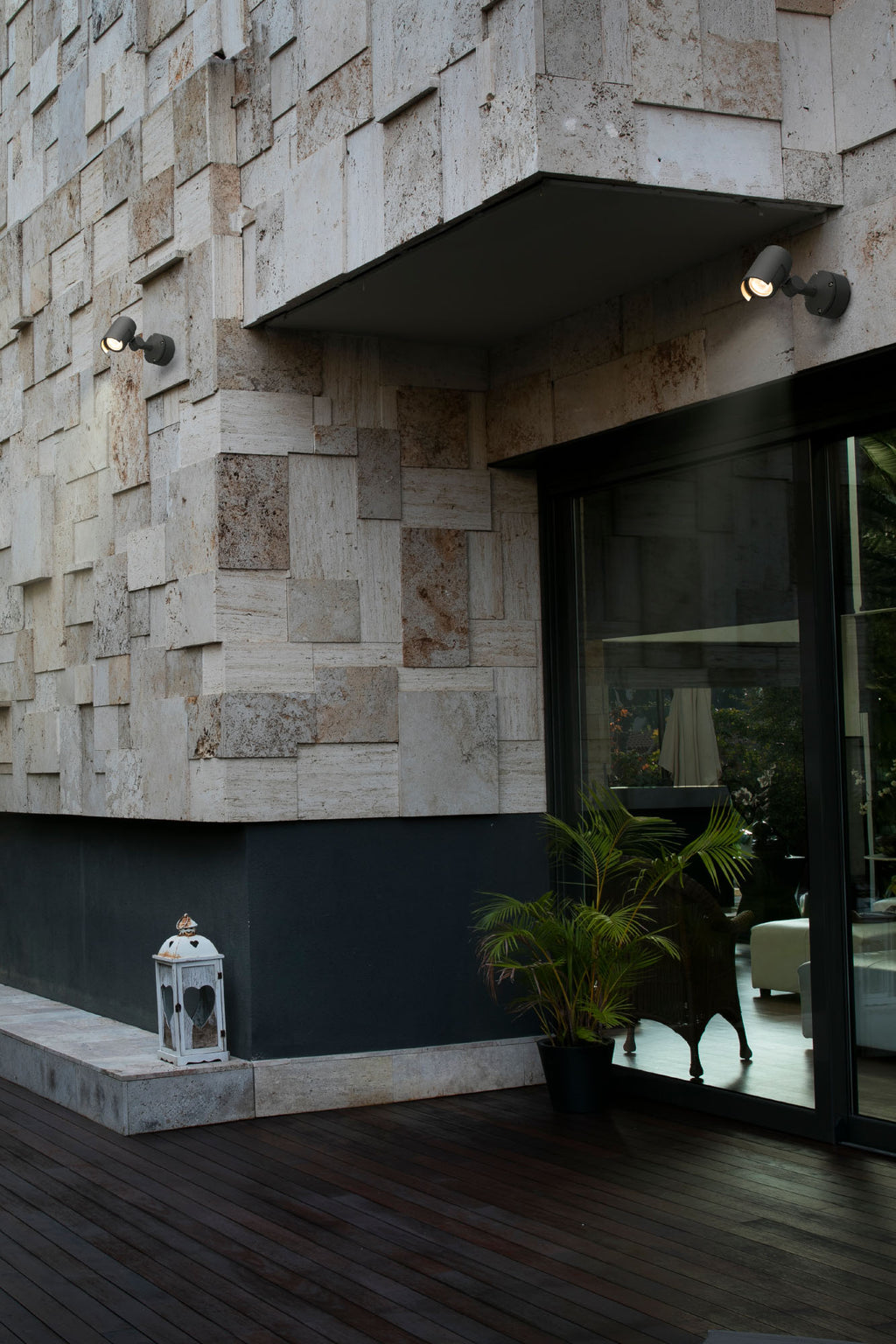 Proyector LED FOC 150 gris oscuro FARO 70156 en ambiente exterior, iluminando jardín y terraza con aluminio IP65 resistente al agua.