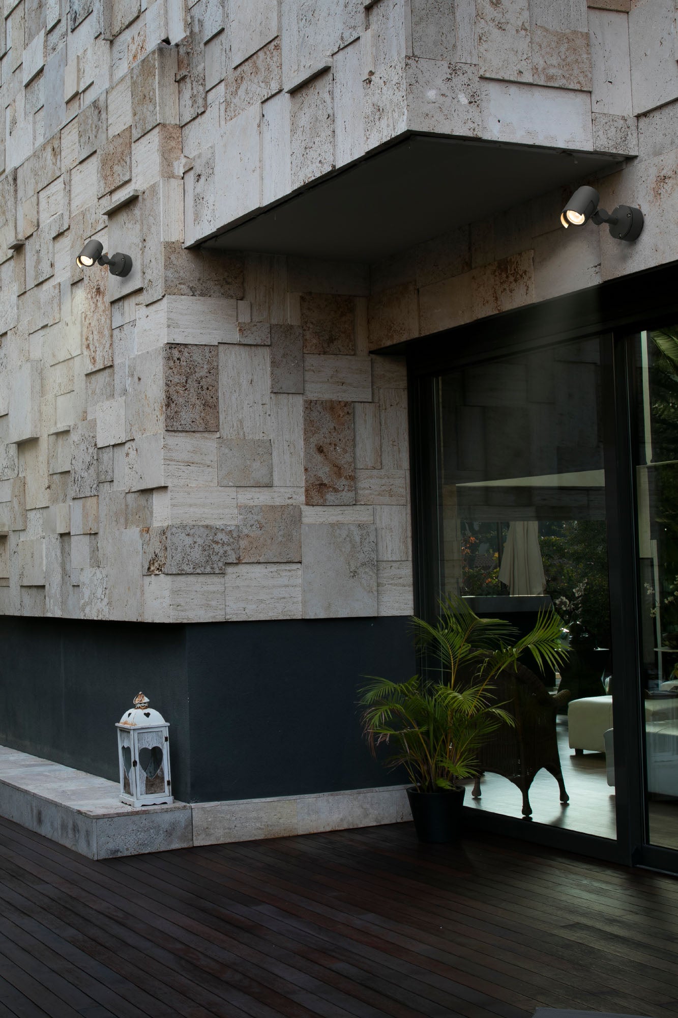 Proyector LED FOC 150 gris oscuro FARO 70156 en ambiente exterior, iluminando jardín y terraza con aluminio IP65 resistente al agua.