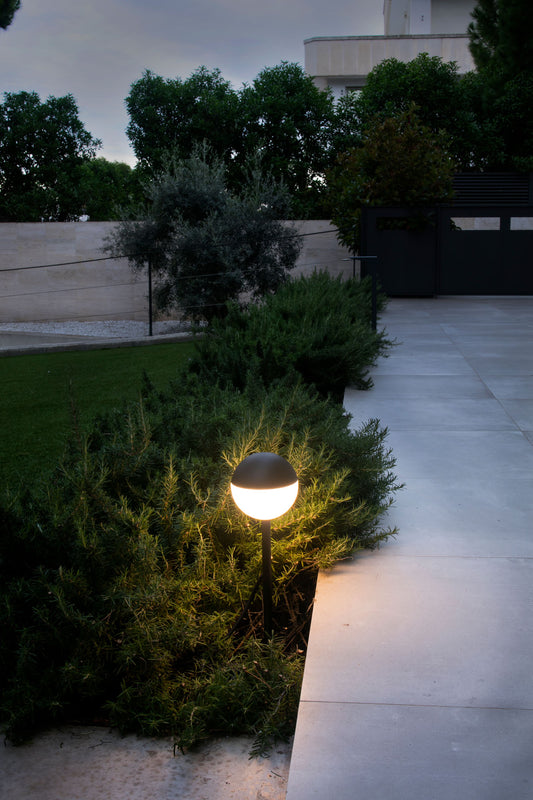 Luminaria estaca PICCOLA en negro modelo FARO 70245 instalada en jardín exterior, iluminación LED decorativa de aluminio y PMMA para exteriores.