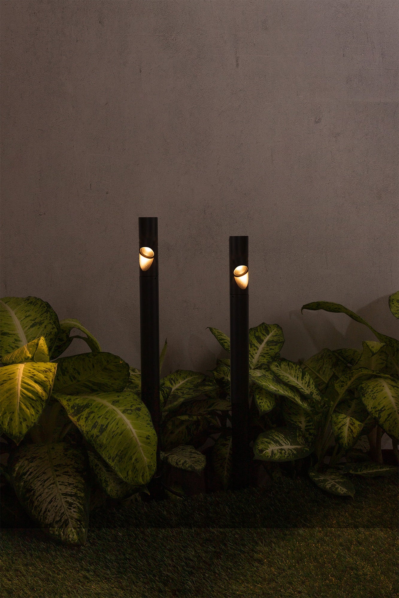 Estaca iluminación BEZEL negro FARO 70248 en ambiente de jardín: luminaria exterior de aluminio IP65 para caminos LED, iluminando senderos nocturnos