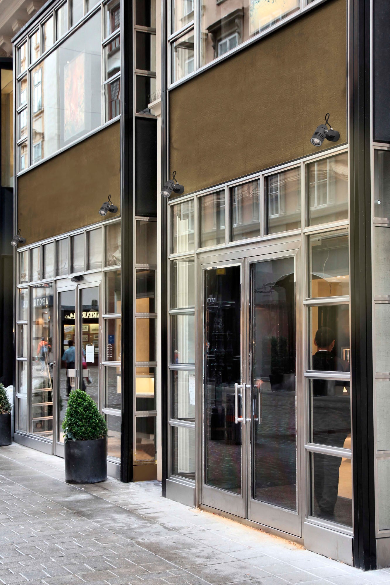 Lámpara proyector LIT gris oscuro FARO 70260 en imagen ambiente exterior, instalada en pared de aluminio IP54 con bombilla GU10 LED para iluminación exterior de la colección 7029