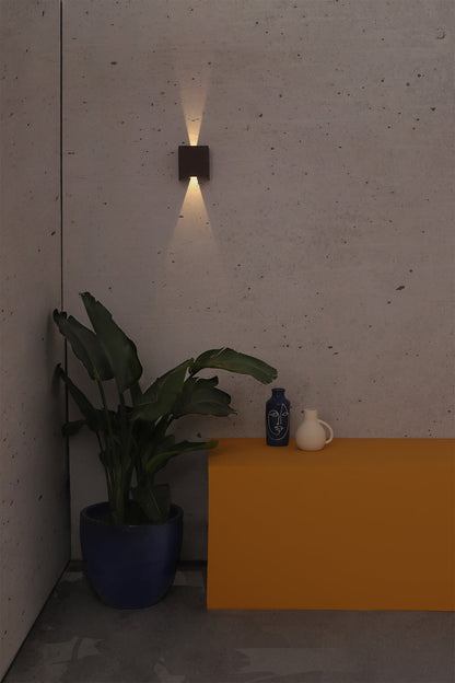 Aplique de pared LED OLAN marrón óxido FARO 70270 en imagen de ambiente, iluminando jardín o terraza exterior con luminaria superficie de aluminio IP65.