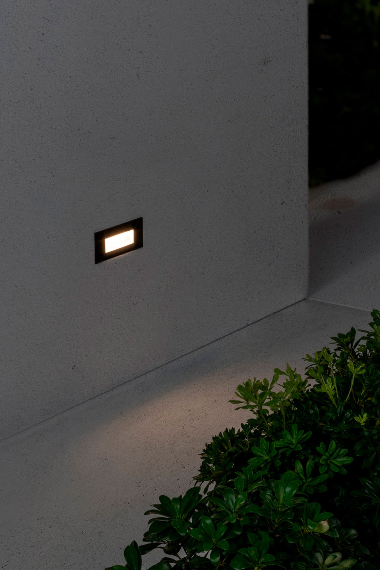 Luz empotrable LED exterior DART RCT negra 2700K FARO 70278 en ambiente de jardín, iluminación cálida policarbonato y cristal para señalización pared