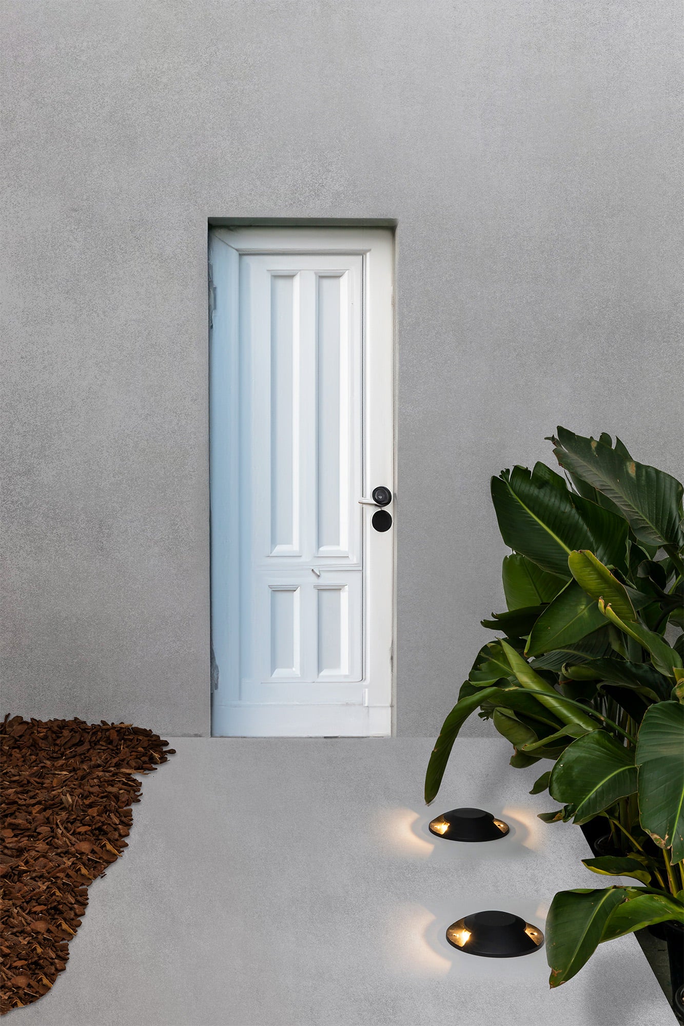 Lámpara superficie exterior LOTH 2L negro de FARO modelo 70286 en ambiente de jardín, iluminando pared con luz LED en aluminio resistente IP67 para señalización exterior