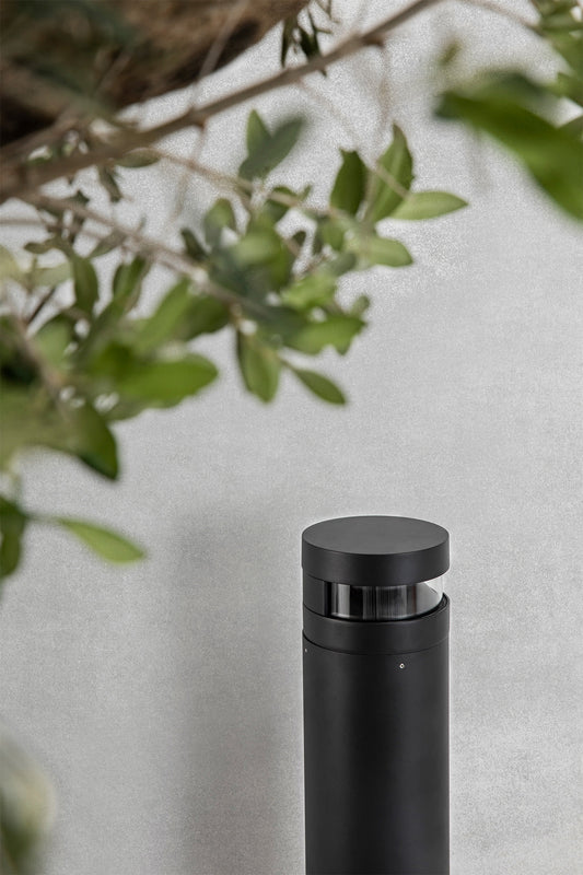 Baliza exterior BAST negra faro LED modelo 70292 en imagen ambiente de jardín, luminaria de superficie en aluminio y policarbonato, iluminación exterior resistente IP65 IK10