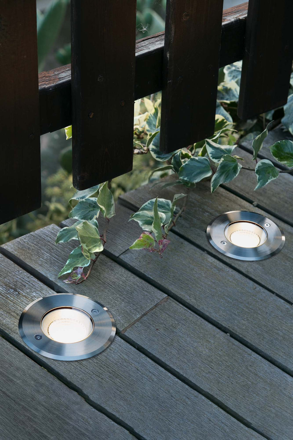 Imagen ambiente de luminaria empotrable LED SURIA 120 Inox 60° modelo FARO 70592N instalada en jardín exterior iluminando terrazas con resistencia IP67 e IK08